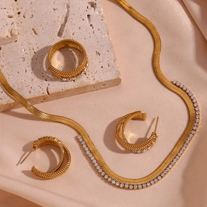 Detailed close-up of 18K gold plated herringbone chain jewelry set with white cubic zirconia