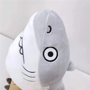 Detailed embroidery of eyes and gills on a gray and white shark plush pillow toy