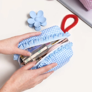 Blue plaid quilted makeup bag with red plush handle and frill trim storage capacity