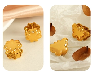 Detailed view of 18K gold butterfly and flower stud earrings with a mirrored metallic finish