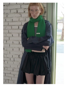 Detail showing the 100% pure wool texture of this green scarf on a stylish model
