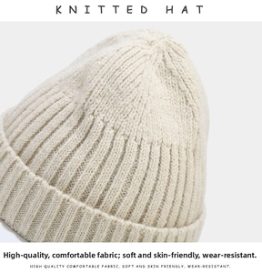 Close-up of beige knitted beanie showing thick vertical stripe texture and warm fabric