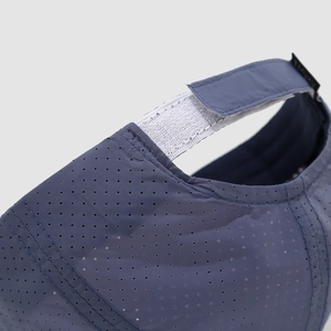 Detail van marineblauwe kinderpet met laserperforaties en klittenbandsluiting