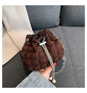 Detail of brown suede drawstring bag with silver chain and pearl decorations