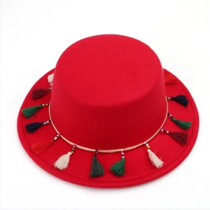 Détail d'un chapeau rouge à bord plat avec glands colorés et perles de style bohème