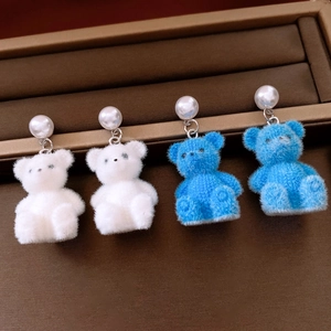 Detail van witte en blauwe geflockte beeroorbellen met parels op een sieradentray