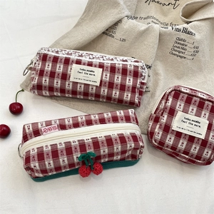 Close-up of red gingham organizers with cherry patterns and elegant lace details