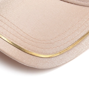 Detail showing mercerized satin fabric and gold metal woven trim on baseball cap brim