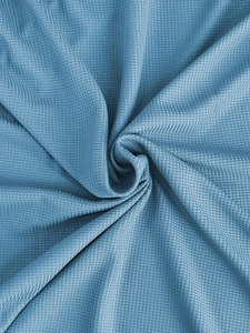 Macro view of blue waffle weave fabric texture with dynamic spiral fold detail