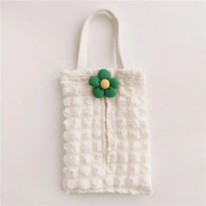 Close-up of white bubble pleated fabric texture with yellow and green flower on a car tissue bag