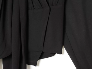 Detail shot of black chiffon fabric showing elegant pleats and soft draped texture on top