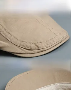 Detailed close-up of stitching quality and twill texture on a beige cotton flat cap