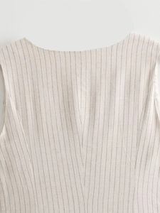 Macro view of tailored striped vest showing beige linen fabric texture and fine stitching