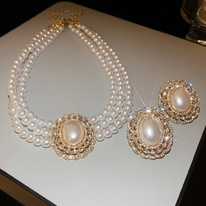 Detail view of multi-layer faux pearl necklace and stud earrings set with crystal accents