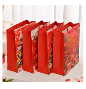 Detail of red Christmas gift bags with festive Santa patterns and rope handles