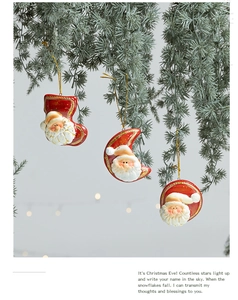 Dettaglio di ciondoli vintage di Babbo Natale in terracotta rossa su un albero di Natale