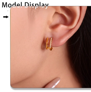 Detailed close-up of gold double-layered C-shaped stud earrings with zircon inlay on a model