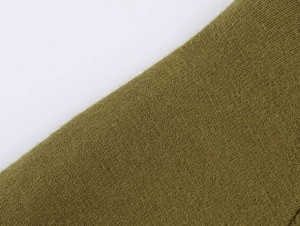 Vista macro della texture in maglia verde oliva con fibre morbide in misto lana