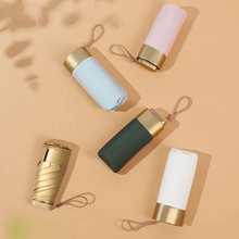 Ultralight six-fold capsule umbrellas in pink blue green gold and white on beige background