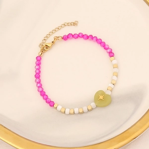 Fashion beaded bracelet with heart stone and pearl charms on a white luxury tray