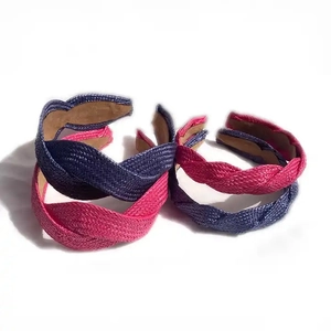 Close-up of twisted braided straw headbands in deep purple and fuchsia pink tones