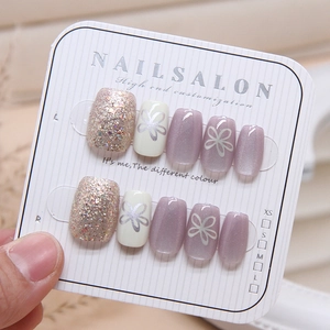 Cat eye press-on nails with handmade purple floral designs and glitter accents