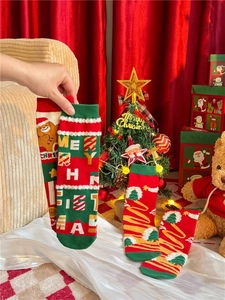 Detail of red Christmas crew socks with gingerbread man patterns and white faux fur trim