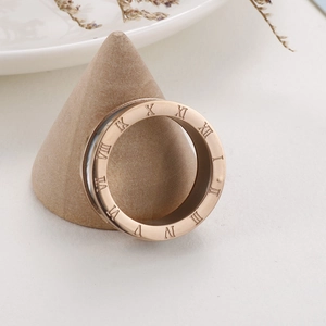 Rose gold stainless steel band ring with Roman numerals on a wooden cone stand