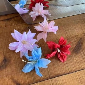 Flat lay of artificial fabric flower hair accessories in pink purple and blue tones