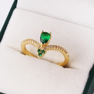 V-shaped gold-plated ring featuring pear-cut emerald zircon and sparkling side stones