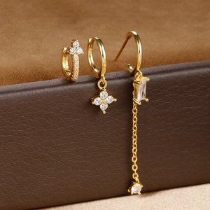 Detailed macro view of a 3-piece gold zircon earring set on a leather display box