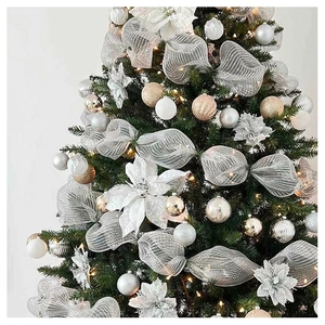 Close-up of decorated Christmas tree with silver mesh ribbon, white flowers and shiny baubles