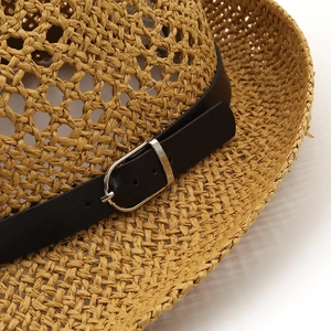Détail du chapeau de paille tissé à la main avec bande en cuir noir et boucle en métal