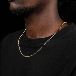 Detail of 3mm gold curb chain necklace showing flat link texture on a black shirt