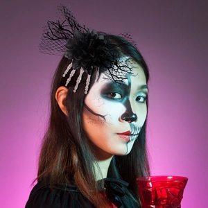 Gothic Halloween hair clip featuring black rose, skull hand bone, and mesh on purple background