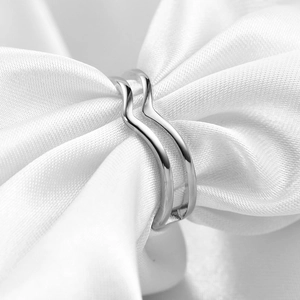 Macro shot of minimalist silver double wave ring nested in white silk ribbon
