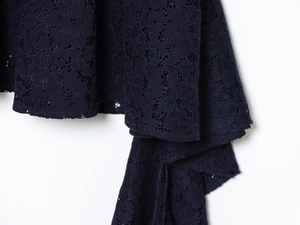 Détail du tissu en dentelle bleu marine montrant des motifs floraux et un beau drapé