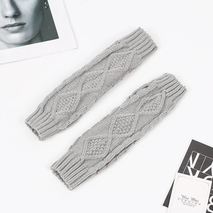 Macro shot of grey knitted arm warmer featuring classic diamond cable texture and ribbed cuffs