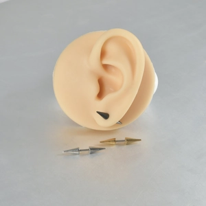 Three-color stainless steel pointed cone cartilage piercings shown on ear model