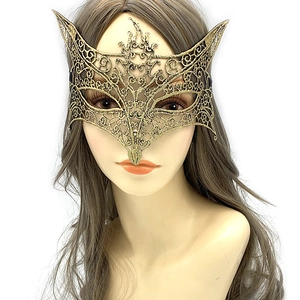 Close-up of gold lace masquerade mask with cat ear design and intricate spiral patterns