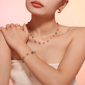 Golden clover jewelry set with green natural stones including necklace and earrings