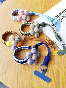 Detail of colorful braided phone wrist straps with cute fabric flowers and metal buckles