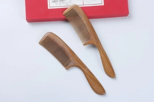 Detailed close-up of premium green sandalwood hair combs with natural wood grain in a gift box