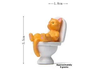 Macro side view of an orange cat figurine sitting on a white toilet, size 3.5cm x 1.8cm
