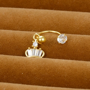Macro detail of a golden crown navel ring with white zircon stones on brown velvet