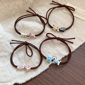 Detailed view of four brown elastic hair ties with cute cartoon resin animal charms