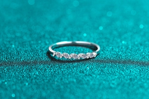 Macro detail of wave-shaped S925 sterling silver ring with sparkling moissanite stones