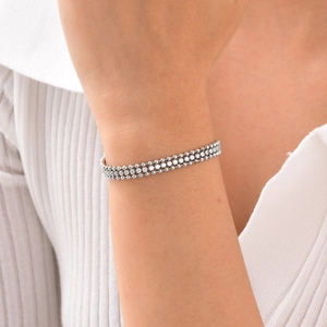 Detail of elegant three-row zircon tennis bracelet in silver finish on a model wrist
