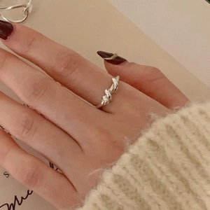 Minimalist 925 sterling silver spiral twist knot ring worn by a model in warm light