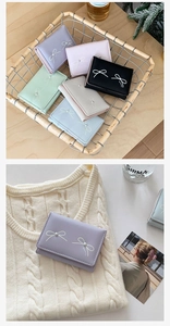 Short wallet for women with bow pearl detail in assorted pastel colors and leather texture